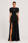Black evening gown with cut-out design and high slit on a white background